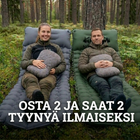 To personer sitter på en grå og grønn Ilmapatja PRO i en furuskog med puter i fanget, tekst om gratis puter