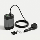 Kannettava ulkosuihku pumpulla, letkulla, käsisuihkulla, pidikkeellä ja USB-kaapelilla vaalealla taustalla