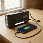 DAB+ -radio lataa matkapuhelinta USB-kaapelin kautta mökkipöydällä, matkapuhelimen näytössä näkyy lataussymboli